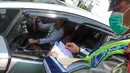 Seorang petugas tampak sedang memberikan surat tilang kepada seorang pengemudi yang parkir sembarangan, Jakarta, Senin (8/9/2014) (Liputan6.com/Faizal Fanani)