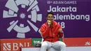 Pebulu tangkis Indonesia, Jonatan Christie mengigit medali emas usai upacara penghargaan cabang olahraga badminton Asian Games 2018 di Jakarta, Selasa (28/8). Jonatan menang atas wakil Chinese Taipei, Chou Tienchen.  (AFP Photo/Sonny Tumbelaka)