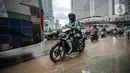 Pengendara melintasi genangan air akibat kebocoran saluran pipa air di kawasan Bundaran Hotel Indonesia (HI), Jakarta, Selasa (11/10/2022). Kebocoran pipa air diduga terimbas proyek revitalisasi Halte Bundaran Hotel Indonesia. (Liputan6.com/Faizal Fanani)