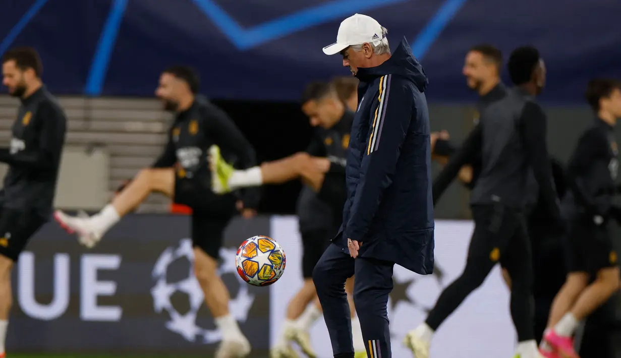 Pelatih Real Madrid, Carlo Ancelotti mengontrol bola saat memimpin sesi latihan Real Madrid di Red Bull Arena Stadium, Leipzig, Senin (12/2/2024) jelang menghadapi RB Leipzig pada leg pertama babak 16 besar Liga Champions 2023/2024. (AFP/Odd Andersen)