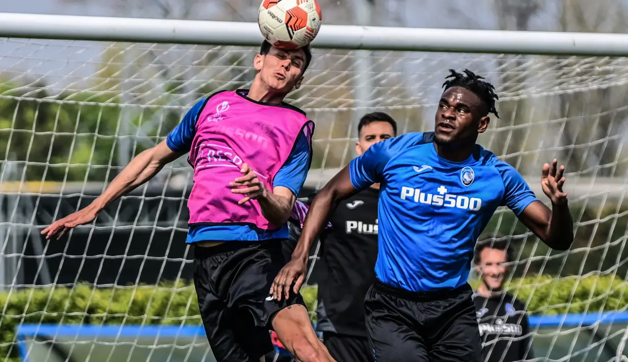 Gelandang Atalanta, Matteo Pessina (kiri) dan penyerang Duvan Zapata berebut bola saat sesi latihan di tempat latihan klub di Ciserano, Bergamo, Italia (13/4/2022). Atalanta akan bertanding melawan RB Leipzig pada leg kedua perempat final Liga Europa di Stadio Atleti Azzurri. (AFP/Miguel Medina)