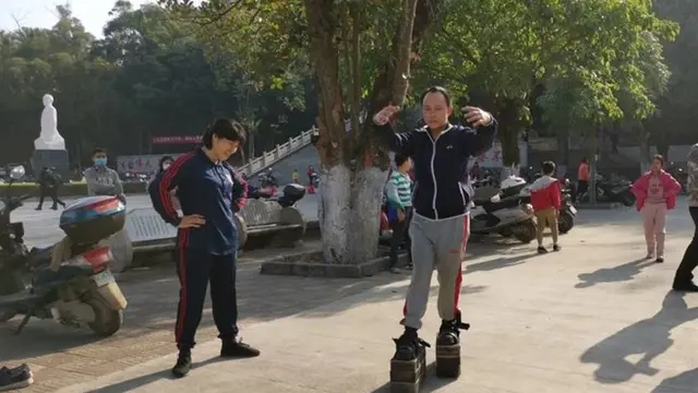 Seorang pria berkepala 5 berjalan pakai sepatu berpelat baja seberat 150 kg.