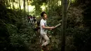 Seorang pegawai memilih bambu yang berisi alkohol di Hutan Yibin, China pada 30 Juli 2016. Metode minuman alkohol yang disimpan di dalam bambu tersebut juga dapat memberikan manfaat pengobatan. (AFP Photo/Fred Dufour)