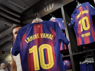 Orang-orang berbelanja jersey baru bernomor punggung 10 dari penyerang Barcelona asal Spanyol, Lamine Yamal, di toko resmi FCB di Barcelona pada 17 Juli 2025. (Manaure QUINTERO/AFP)