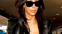 Mengenakan pakaian serba hitam dan kacamata gelap, Kim Kardashian memasuki pintu gerbang keberangkatan bandara LAX.