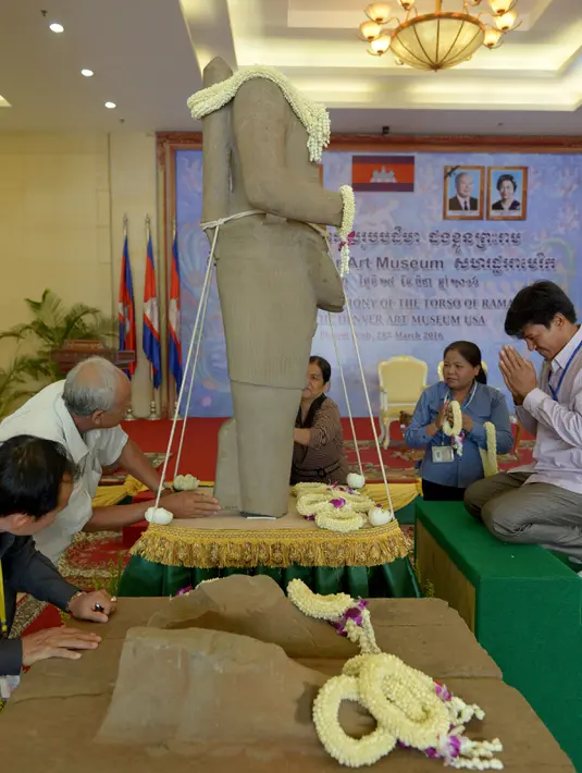 Perwakilan Kamboja berdoa di dekat patung Dewa Rama abad ke-10 yang dikembalikan Museum Seni Denver, AS, dalam sebuah upacara di Phnom Penh, Senin (28/3). Patung setinggi 1,5 meter itu dicuri pada era 1970-an dari Candi Koh Ker. (TANG CHHIN SOTHY/AFP)