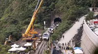 Petugas penyelamat memindahkan bagian dari kereta yang tergelincir dekat Ngarai Taroko di Hualien, Taiwan, Sabtu (3/4/2021). Kereta delapan gerbong yang berisi 494 orang itu berangkat dari Taipei menuju Taitung saat kecelakaan. (AP Photo/Chiang Ying-ying)