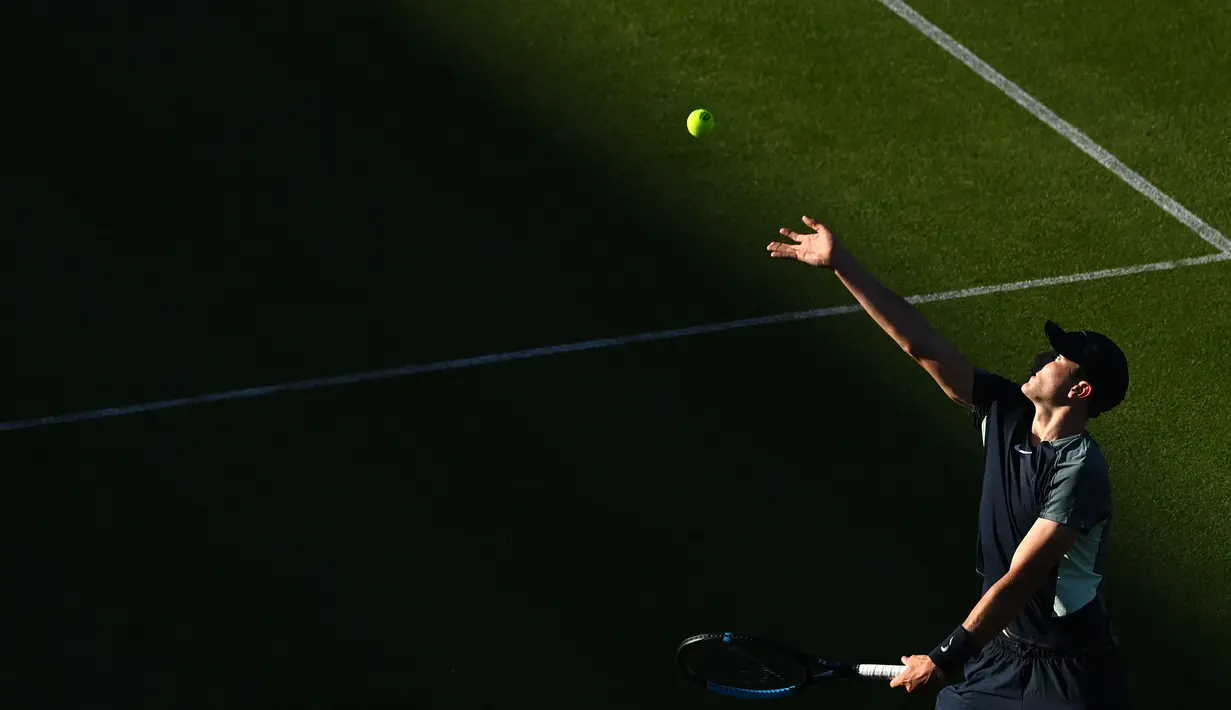 Petenis Inggris, Jack Draper melakukan servis menuju petenis Argentina, Diego Schwartzman saat putaran 8 pertandingan tenis tunggal putra pada hari keempat turnamen tenis Eastbourne International di Eastbourne, Inggris pada 22 Juni 2022. (AFP/Glyn Kirk)