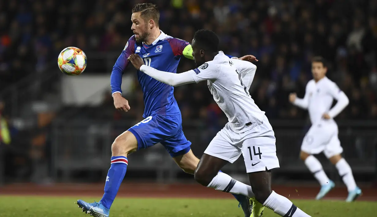 Gelandang Islandia, Gylfi Sigurdsson, berusaha melewati gelandang Prancis, Blaise Matuidi, pada laga Kualifikasi Piala Eropa 2020 di Reykjavik, Sabtu (11/10). Islandia kalah 0-1 dari Prancis. (AFP/Jonathan Nackstrand)