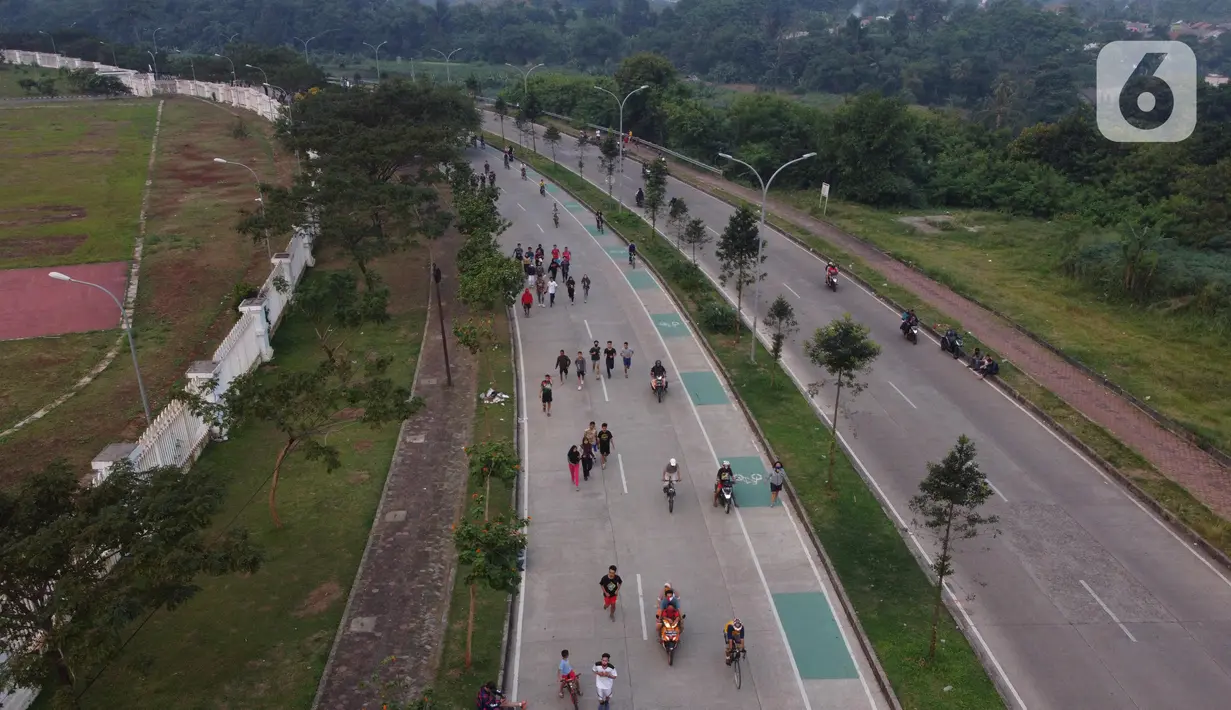 Foto udara memperlihatkan aktivitas warga di jalan lingkar kawasan Stadion Pakansari, Kabupaten Bogor, Jawa Barat, Minggu (28/6/2020). Meski area tersebut belum dibuka kembali, namun warga tetap masuk untuk melakukan beragam aktivitas di kawasan tersebut. (Liputan6.com/Helmi Fithriansyah)
