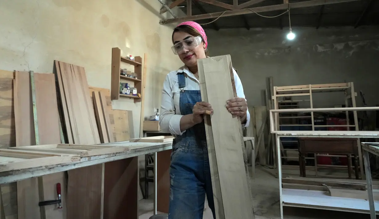 Tukang kayu Iran Sahar Biglari membawa kayu saat bekerja di bengkelnya di Teheran, Iran, 12 Maret 2023. Semakin banyak perempuan Iran berjuang untuk mengatasi hambatan gender. (AP Photo/Vahid Salemi)
