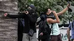 Demonstran berselfie ketika yang lain menggunakan ketapel menyerang polisi selama bentrok memprotes kebijakan ekonomi pemerintah di Santiago (6/11/2019). Presiden Chile mengatakan "tidak menyembunyikan apa-apa" mengenai tuduhan bahwa polisi membunuh, menyiksa warga sipil. (AFP Photo/Javier Torres)