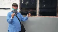 Karyawan PT Langgam Harmoni memperlihatkan kaca rumah yang dirusak orang tak dikenal. (Liputan6.com/M Syukur)