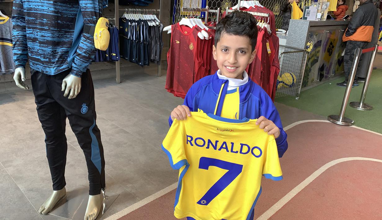 Stok Jersey Al Nassr pun hampir habis akibat membludaknya permintaan. Bahkan beberapa fans akhirnya banyak yang membawa jersey mereka sendiri hanya untuk disablon dengan menambahkan nomor dan nama Ronaldo. (AFP/Fayez Nureldine)