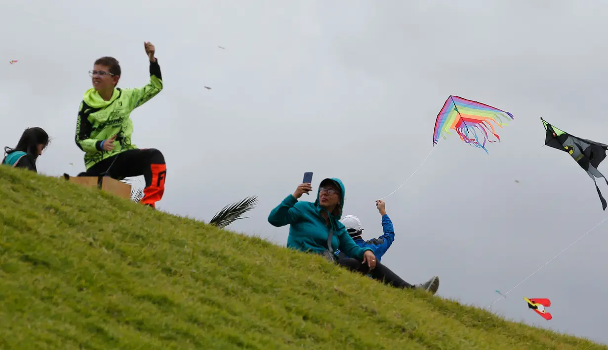 Orang-orang menerbangkan layang-layang selama festival musim panas di taman Simon Bolivar, Bogota, 12 Agustus 2018. Layang-layang beraneka warna dan bentuk menghiasi ibu kota Kolombia tersebut. (AFP PHOTO/John VIZCAINO)