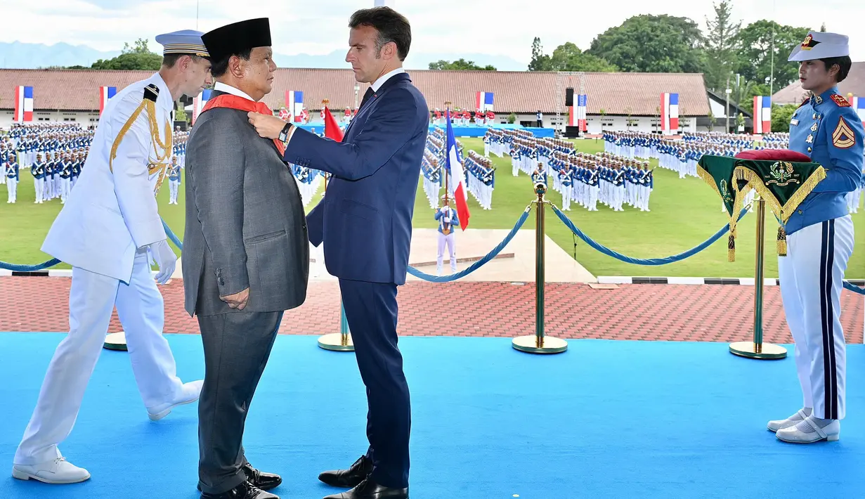 Foto selebaran yang diambil dan dirilis pada 29 Mei 2025 oleh Istana Kepresidenan ini menunjukkan Presiden Prancis Emmanuel Macron (kanan depan) menganugerahkan penghargaan Grand Croix de la LÈgion díHonneur kepada Presiden Indonesia Prabowo Subianto dalam kunjungannya di Akademi Militer, Magelang, Jawa Tengah, Kamis 29 Mei 2025. (Handout/Istana Kepresidenan Indonesia/AFP)