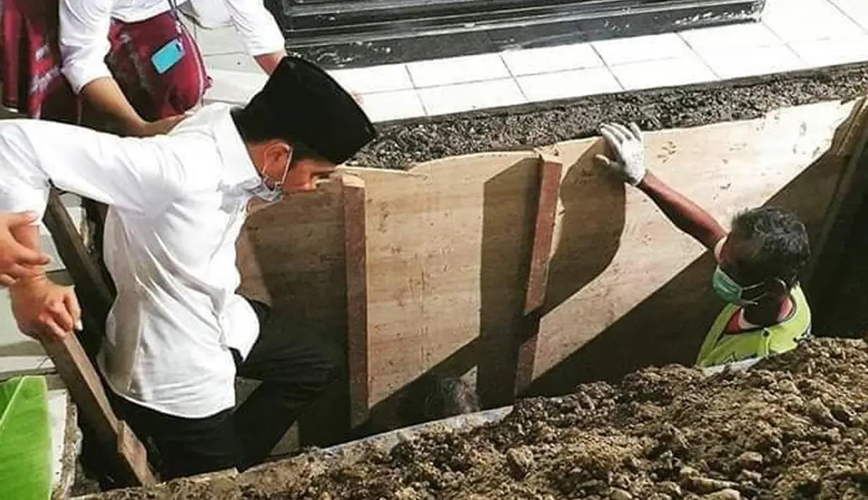 Presiden Joko Widodo atau Jokowi saat turun ke liang lahat untuk memakamkan jenazah ibundanya Sudjiatmi Notomihardjo di pemakaman keluarga di Mundu, Kabupaten Karanganyar, Jawa Tengah, Kamis (26/3/2020). Sujiatmi Notomiharjo wafat pada Rabu 25 Maret 2020 pukul 16.45 WIB. (dok.istimewa)