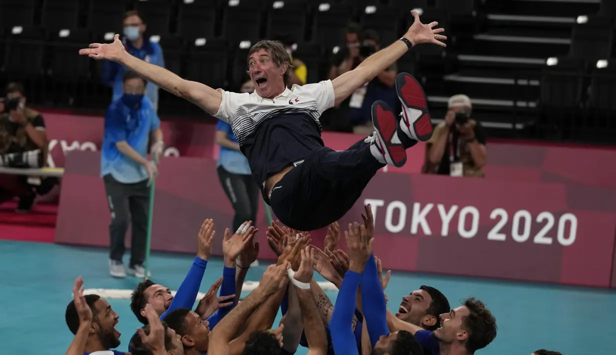 Pemain Prancis melemparkan pelatih kepala Laurent Tillie ke udara saat mereka merayakan kemenangan atas Russian Olympic Committee pada pertandingan final bola voli putra Olimpiade Tokyo 2020 di Tokyo, Jepang, Sabtu (7/8/2021). Prancis mengalahkan ROC 3-2. (AP Photo/Frank Augstein)