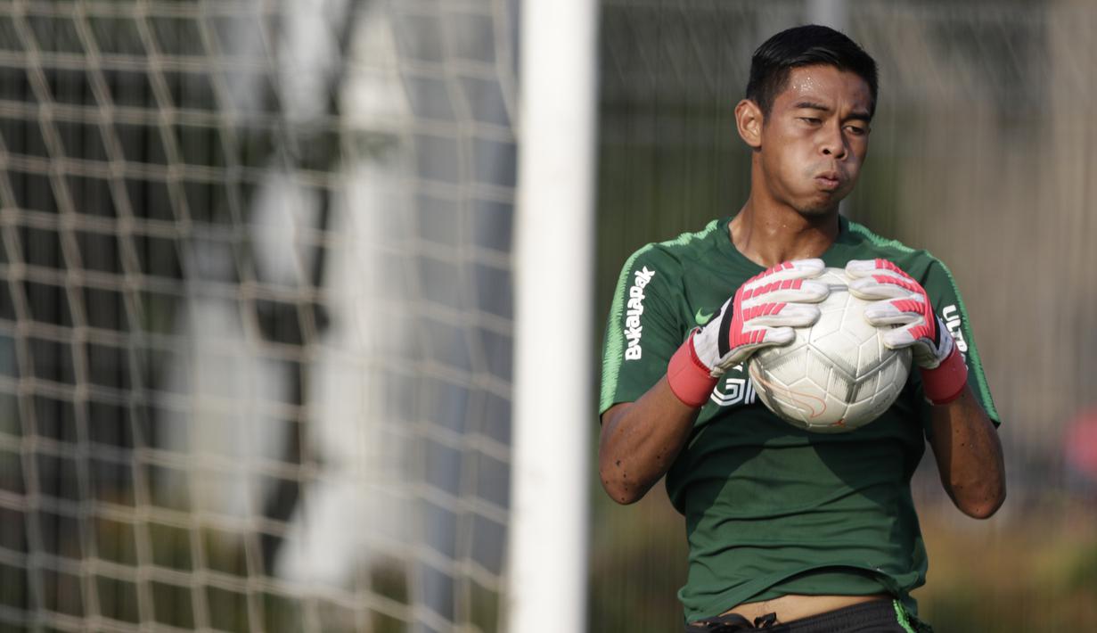 Kiper Timnas Indonesia U-22, Satria Tama, menangkap bola saat latihan di Lapangan ABC Senayan, Jakarta, Kamis (14/2). Latihan ini merupakan persiapan terakhir jelang Piala AFF U-22 2019 di Kamboja. (Bola.com/M. Iqbal Ichsan)