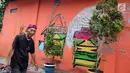 Warga melintas dengan latar belakang warna-warni cat dinding dan grafiti di Kampung Bekelir, Babakan Kota Tangerang, Jumat (16/11). Kampung yang semula kumuh dihiasi dengan cat pacific paint. (Liputan6.com/Fery Pradolo)