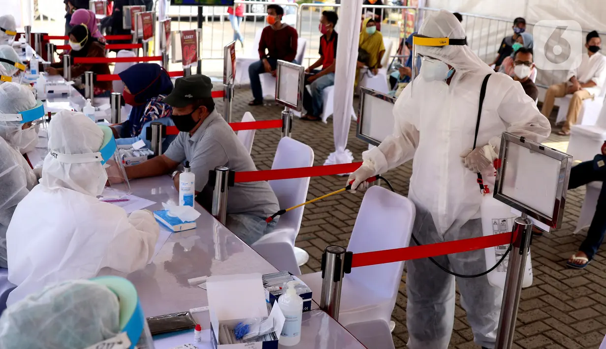 Petugas menyemprotkan cairan disinfektan saat rapid test massal di Kota Tangerang, Banten, Sabtu (30/5/2020).  Badan Intelijen Negara (BIN) menggelar tes diagnostik cepat (rapid rest) massal kepada warga Ciledug sebagai salah satu upaya pengendalian transmisi COVID-19. (Liputan6.com/Angga Yuniar)