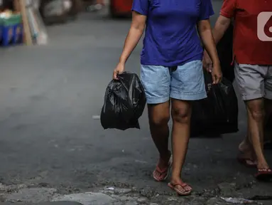 Warga membawa barang belanjaan dengan menggunakan kantong plastik di Kawasan Pasar Jatinegara, Jakarta, Selasa (30/6/2020). Pemerintah Provinsi DKI Jakarta bakal resmi menerapkan larangan penggunaan kantong plastik sekali pakai mulai Rabu, 1 Juli 2020 besok. (Liputan6.com/Faizal Fanani)