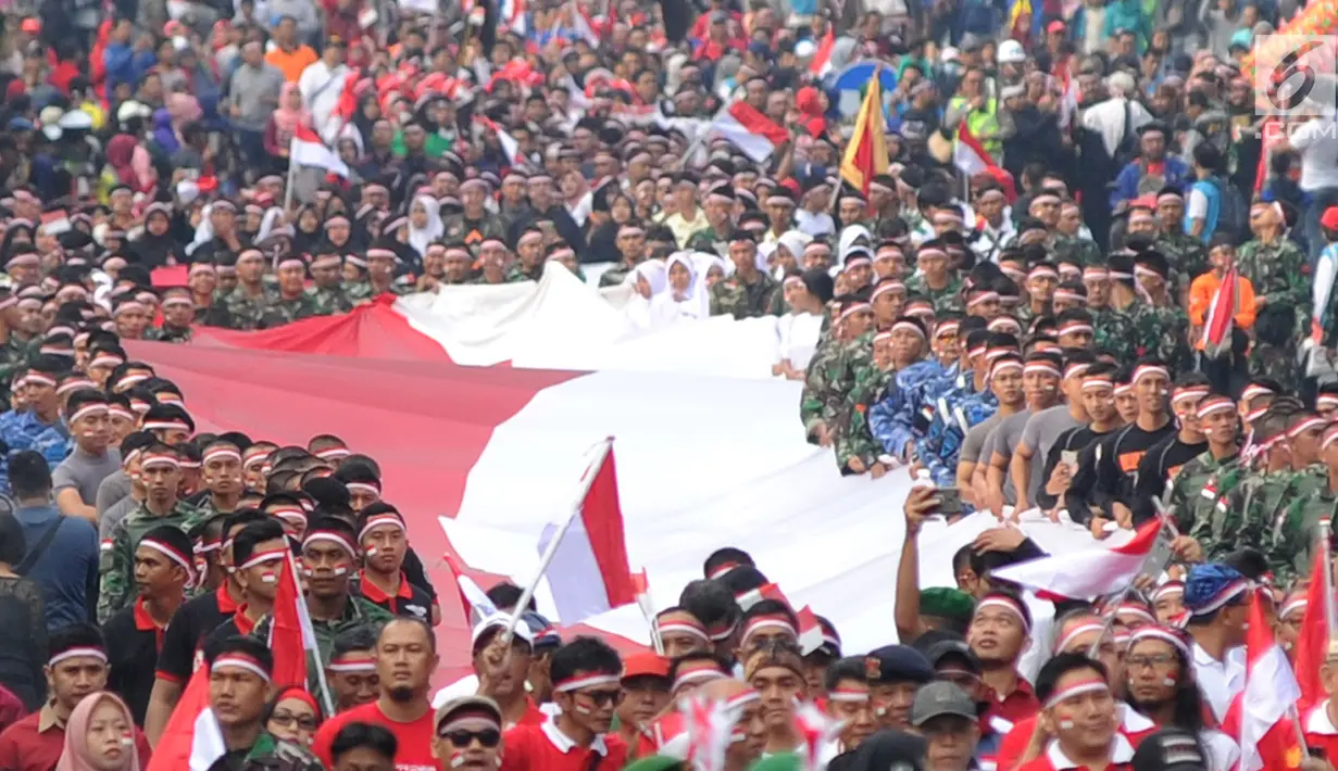 Anggota TNI POLRI  bersama warga masyarakat membawa bendera raksasa berukuran panjang 117 meter dan lebar 5 meter saat gelaran Festival Merah-Putih (FMP) 2018 di kawasan Air Mancur, Bogor ,  Minggu (5/8). (Merdeka.com/Arie Basuki)