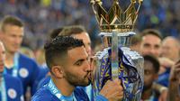 Riyad Mahrez mencium trofi Premier League 2015-2016 usai melawan Everton di King Power Stadium Leicester, Leicester, (07/5/2016).  (EPA/Peter Powell)