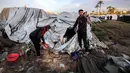 Untuk diketahui, kondisi kemanusiaan di Deir el-Balah terus memburuk, seiring meningkatnya intensitas serangan Israel di wilayah yang sebelumnya dianggap sebagai salah satu tempat perlindungan terakhir bagi pengungsi Palestina di Gaza. Tampak dalam foto, warga memeriksa kerusakan akibat udara Israel menghantam sebuah lokasi dekat tenda-tenda penampungan pengungsi Palestina di Deir el-Balah, Jalur Gaza tengah pada 25 Maret 2026. (Eyad Baba/AFP)