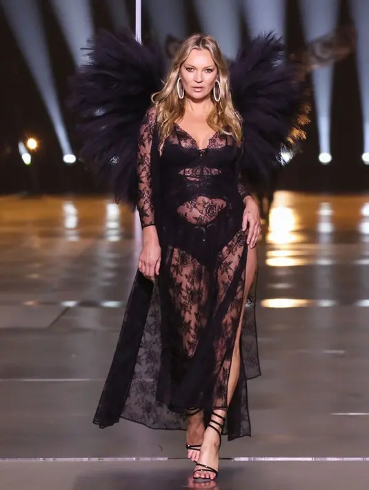 Ibu satu anak Kate Moss tampil memesona dengan lingerie full renda warna hitam yang dipadukan dengan sayap warna senada. [@runway.dolls]