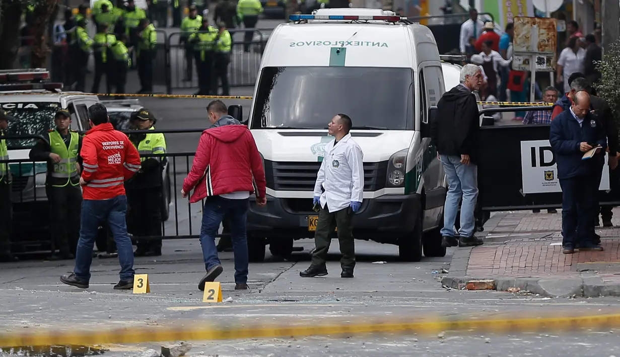 Kendaraan medis terlihat di lokasi ledakan di dekat arena adu banteng Plaza Santamaria di pusat kota Bogota, Kolombia, Minggu (19/2). Satu orang polisi tewas dan sebanyak 30 orang terluka, yang sebagian besar adalah polisi. (STR/AFP)