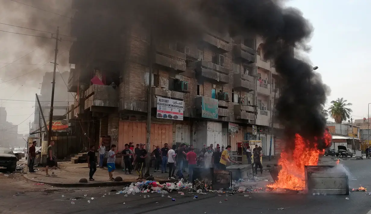 Pengunjuk rasa antipemerintah membakar sejumlah benda dan memblokir jalan saat menggelar protes di Baghdad, Irak, Rabu (2/10/2019). Pengunjuk rasa menginginkan pekerjaan dan layanan publik yang lebih baik. (AP Photo/Hadi Mizban)