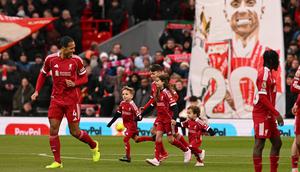 Anak-anak Diogo Jota ikut berjalan ke lapangan sebagai pendamping maskot pemain saat Liverpool versus Wolverhampton Wanderers pada laga pekan ke-18 Premier League di Stadion Anfield, Sabtu (27/12/2025) malam WIB. (AFP/Oli Scarff)
