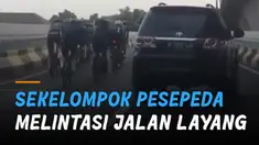 Sekelompok pesepeda terekam melintas  jalan layang yang di situ terdapat rambu larangan sepeda tidak boleh melintas.