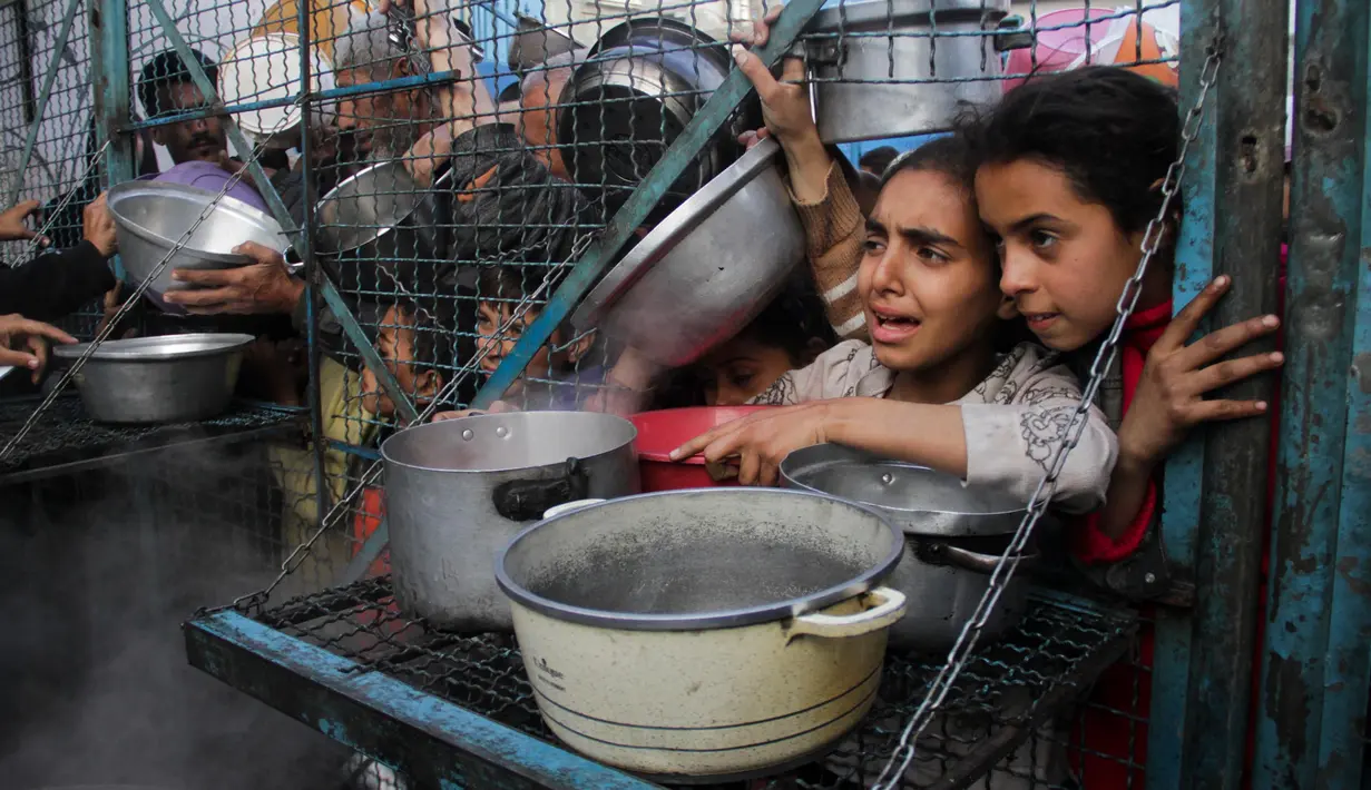 Ratusan warga Palestina termasuk anak-anak berbondong-bondong mendatangi pusat distribusi bantuan. (AP Photo/Mahmoud Essa)