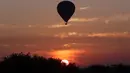 Sebuah balon udara terbang di atas kuil tua selama matahari terbit di Bagan, distrik Nyaung U, Myanmar tengah (16/12). Di Bagan, ada tiga balon yang bisa memuat delapan orang dan dua balon yang bisa memuat dua belas orang. (AP Photo/Aung Shine Oo)