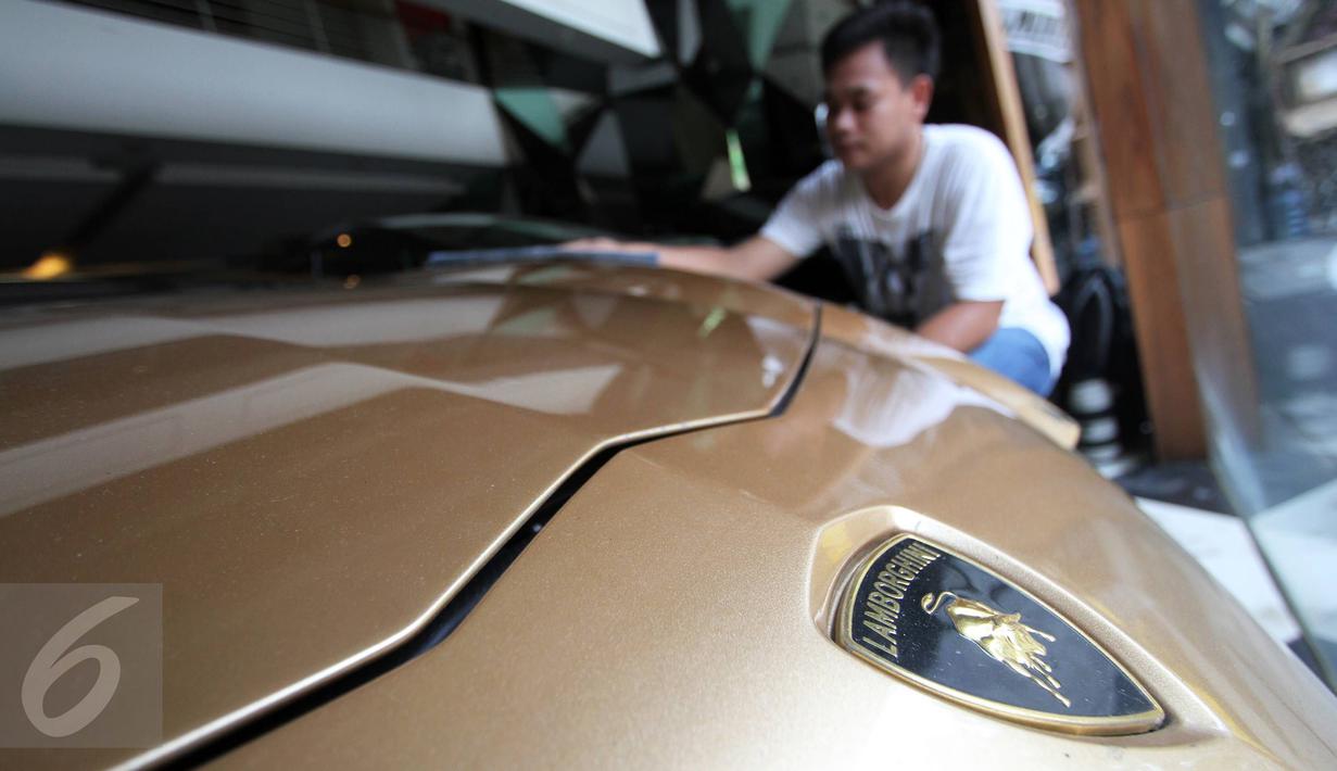 Petugas membersihkan mobil Lamborghini Aventador LP 700-4 tahun 2013 di Auto One Cars Boutique, Jakarta, Senin (5/10/2015). Mobil sport mewah tersebut akan dilelang DJKN Kemenkeu dengan nilai limit Rp 8,26 miliar. (Liputan6.com/Immanuel Antonius)