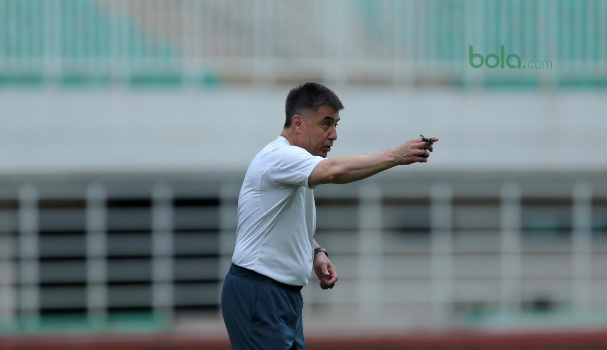 Pelatih Uzbekistan, Ravshan Khaydarov  memberikan instruksi pada uji coba lapangan di Stadion Pakansari, Bogor, (26/4/2018). Uzbekistan merupakan salah satu tim yang akan mengikuti ajang PSSI Anniversarry Cup 2018. (Bola.com/Nick Hanoatubun)