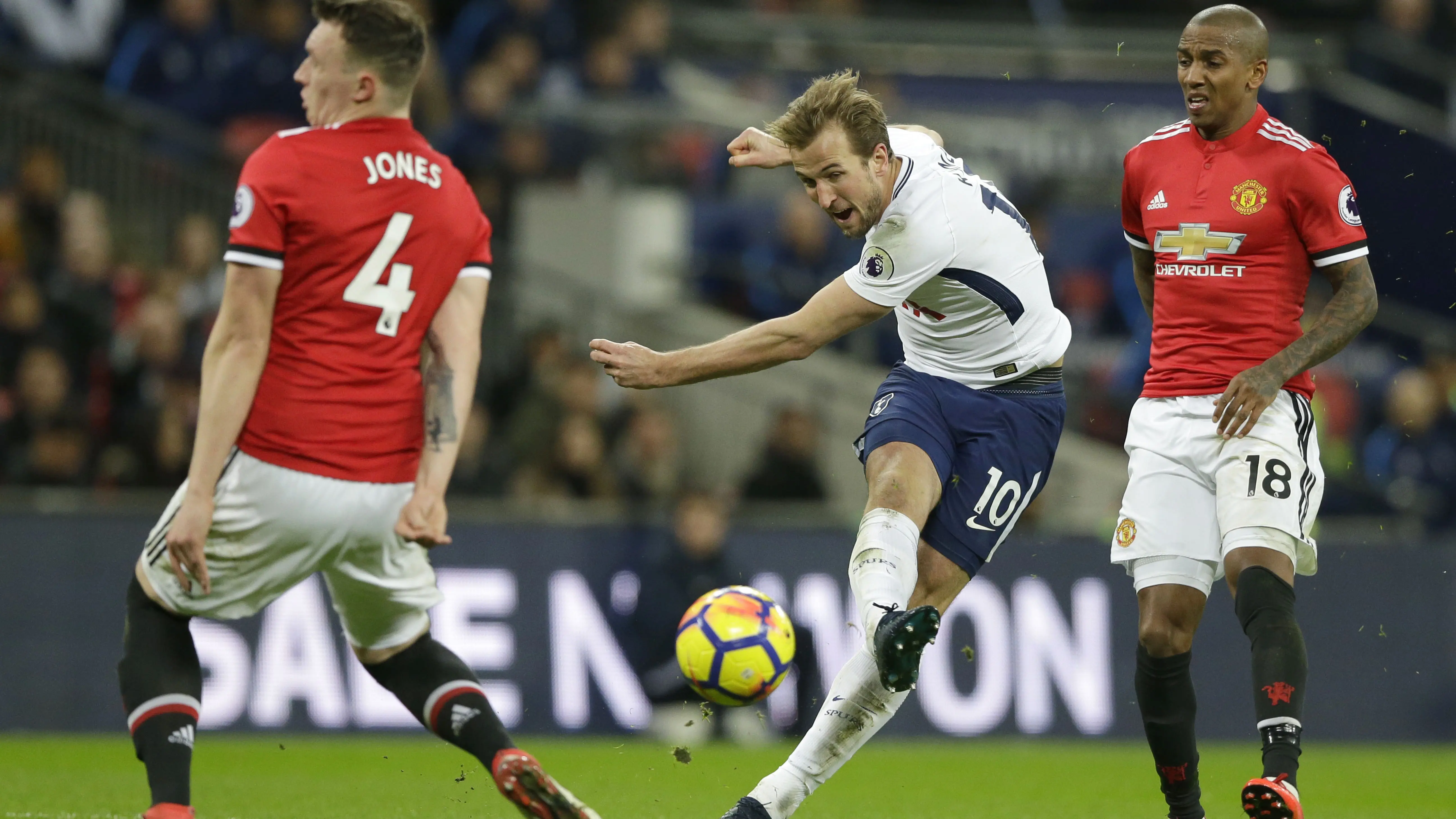 Aksi pemain Tottenham, Harry Kane (tengah) melepaskan tembakan melewati adangan dua pemain Manchester United pada lanjutan Premier League di Wembley stadium, (31/1/2018). Spurs menang 2-0. (AP/Alastair Grant)