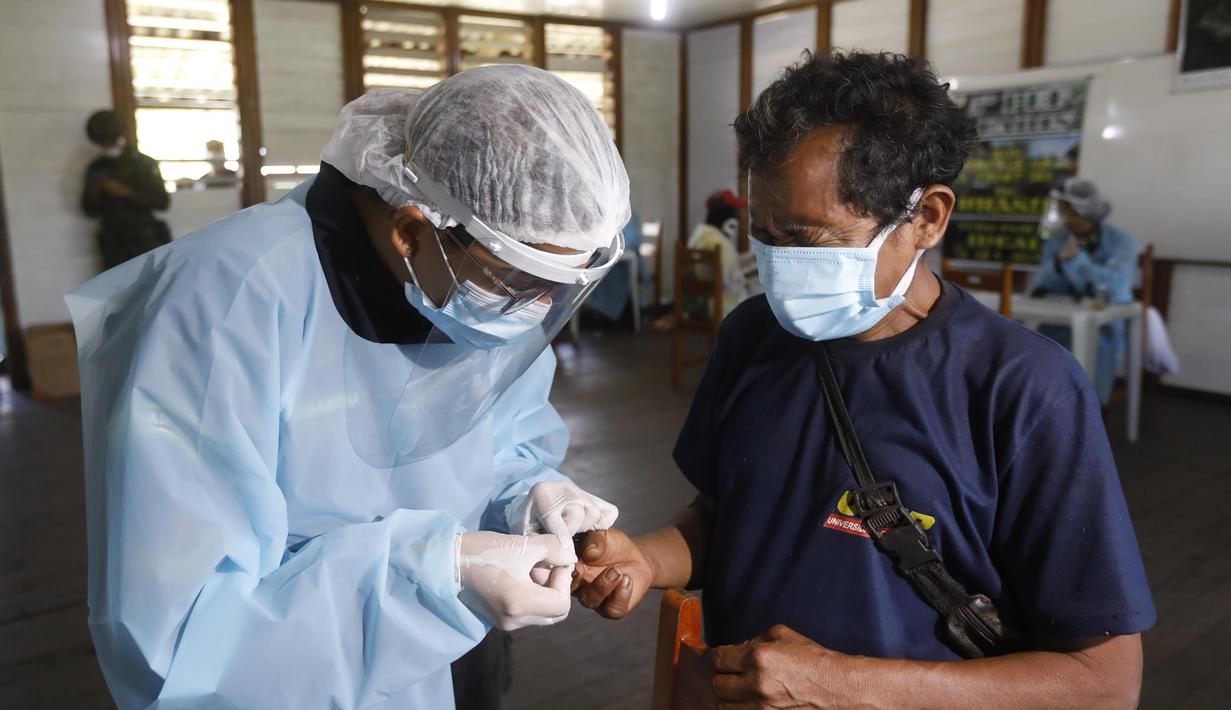 Pekerja medis mengumpulkan sampel tes COVID-19 dari seorang penduduk pribumi di Negara Bagian Roraima, Brasil (30/6/2020). Tim medis militer Brasil menyediakan perawatan medis bagi masyarakat pribumi mulai 30 Juni hingga 5 Juli, termasuk tes COVID-19. (Xinhua/Lucio Tavora)