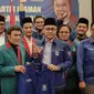 Ketum PAN dan Ketum Partai Idaman Rhoma Irama memegang jas sambil berfoto bersama kadernya saat deklarasi bergabungnya Partai Idaman ke PAN di Jakarta, Sabtu (12/5). (Liputan6.com/Faizal Fanani)