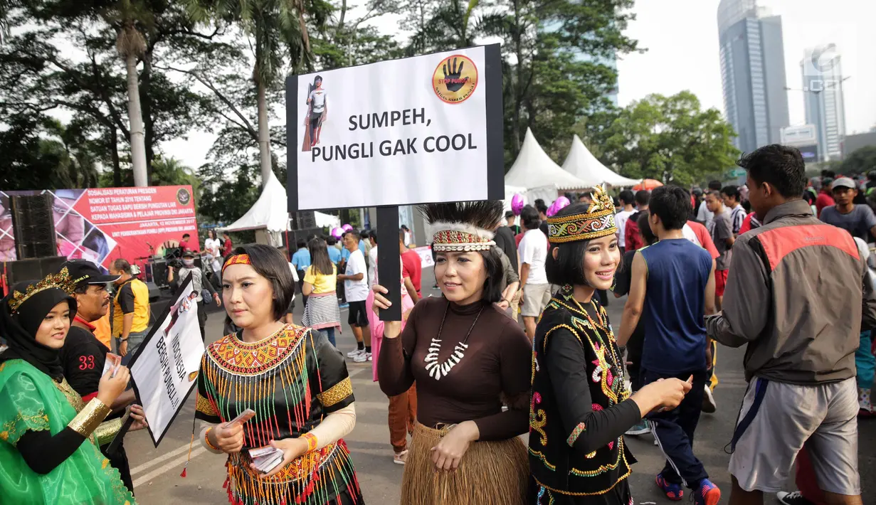 Satgas saber pungli mengenakan kostum tradisional mensosialisasikan tolak pungli di Car Free Day, Jakarta, Minggu (12/11). Satgas saber juga gencar melakukan sosialisasi adanya tim khusus untuk menindak tindakan pungli. (Liputan6.com/Faizal Fanani)