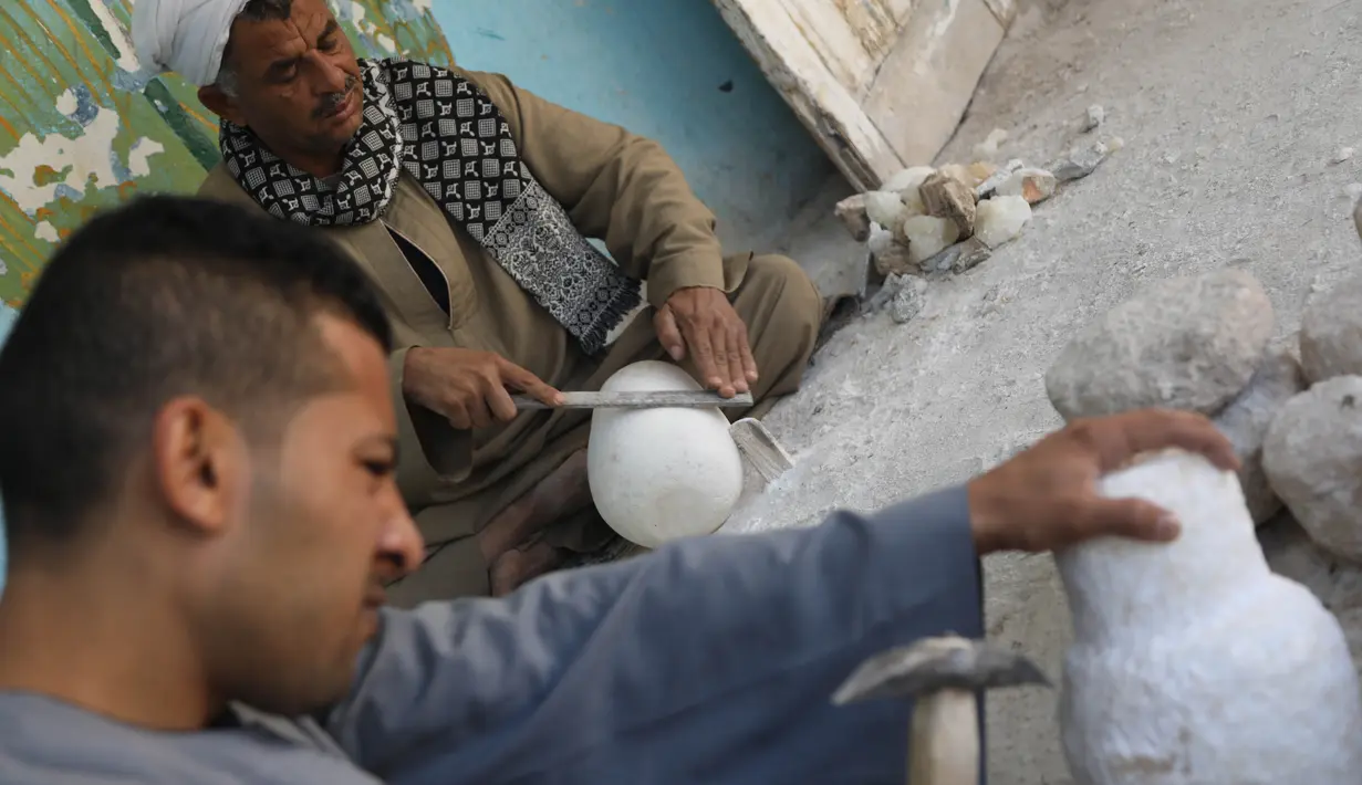 Para pemahat bekerja di sebuah bengkel kerajinan alabaster atau sejenis batu pualam di Desa Gurna, Luxor, Mesir, 17 Desember 2020. Desa Gurna terkenal sebagai penghasil kerajinan tangan dan suvenir bergaya Mesir kuno yang dibuat dari pahatan alabaster. (Xinhua/Ahmed Gomaa)