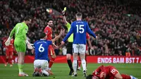 Wasit Sam Barrott memberikan kartu kuning kepada bek Everton asal Inggris #06 James Tarkowski atas pelanggaran terhadap gelandang Liverpool asal Argentina #10 Alexis Mac Allister selama pertandingan Liga Primer Inggris antara Liverpool dan Everton di Anfield di Liverpool, Inggris barat laut, Kamis dini hari WIB (3-4-2025). (Paul ELLIS/AFP)