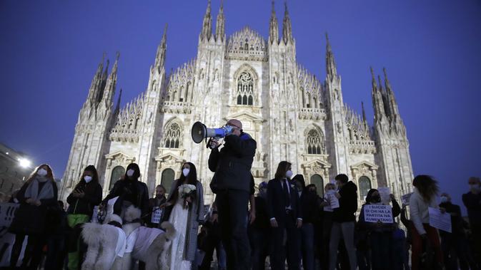 Pemilik toko dan pekerja memprotes langkah-langkah pembatasan pemerintah untuk mengekang penyebaran COVID-19, di depan katedral gothic Milan, Italia, 12 November 2020. Beban kasus baru Infeksi COVID-19 sehari-hari Italia dikonfirmasi naik jauh lebih tinggi pada hari Kamis. (AP Photo/Luca Bruno)