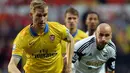 Pemain Arsenal Per Mertesacker di hadang oleh pemain Swansea City Jonjo Shelvey Pada pertandingan Liga Premier Inggris antara Swansea City dan Arsenal di Stadion Liberty di Swansea (28/09/13). (AFP/Paul Ellis)