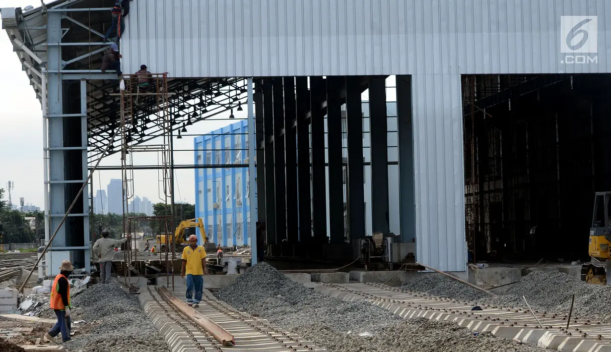 Pekerja menyelesaikan proyek pembangunan depo lokomotif di Cipinang, Jakarta, Jumat (29/12). Depo lokomotif tersebut merupakan bagian dari proyek pembangunan jalur rel dwiganda atau double-double track Manggarai-Cikarang. (Liputan6.com/JohanTallo)