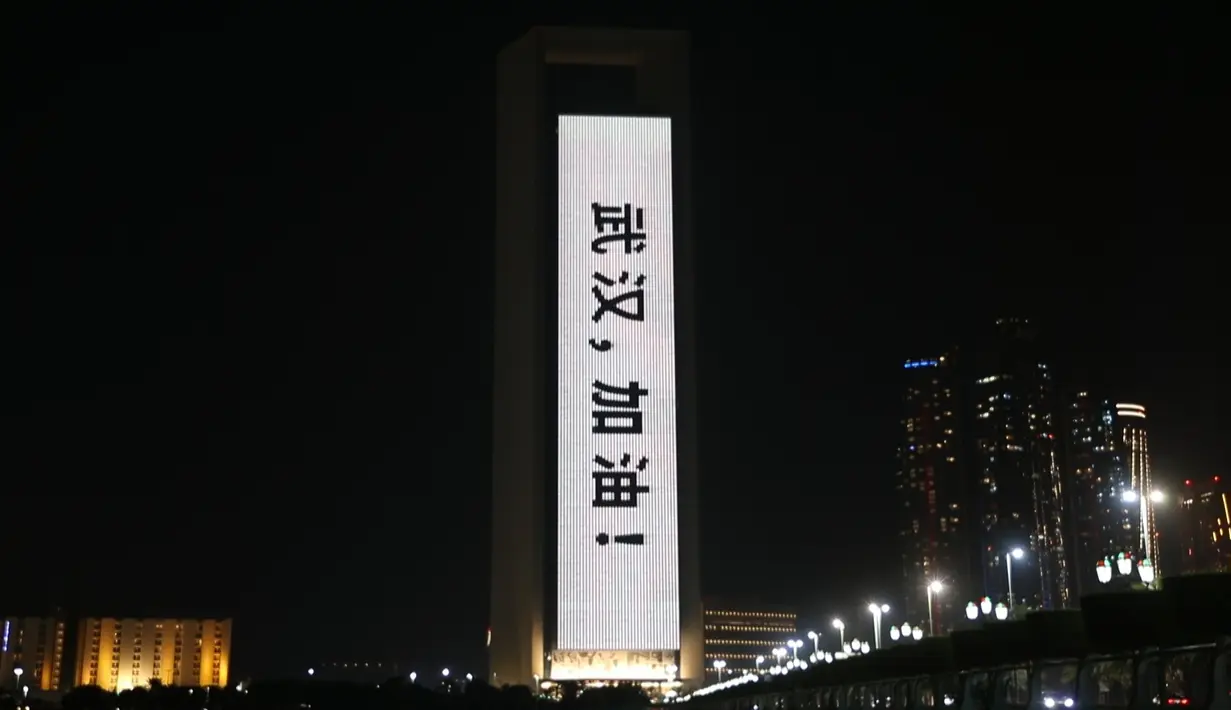 Bangunan Perusahaan Minyak Nasional Abu Dhabi (ADNOC) diterangi dengan slogan-slogan dalam huruf fonetik China yang berarti 'Wuhan, semangat' di Abu Dhabi, Uni Emirat Arab (UEA), Minggu (2/2/2020). Hal tersebut untuk memberi semangat kepada China dalam perang melawan virus corona. (Xinhua/WAM)