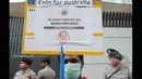Anggota Garda Pemuda Nasdem membawa poster bergambar Tonny Abbott saat menyerahkan ribuan koin untuk PM Tony Abbot di depan kantor Kedutaan Besar Australia, Jakarta, Jumat (27/2/2015). (Liputan6.com/Herman Zakharia)
