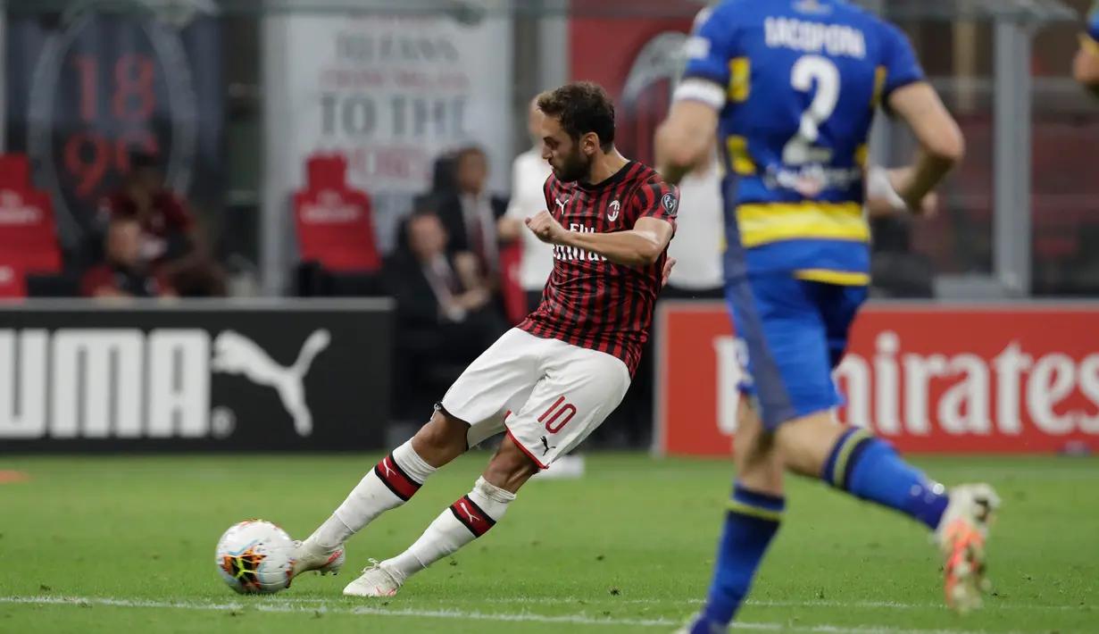 Gelandang AC Milan, Hakan Calhanoglu menembak bola saat bertanding melawan Parma pada pertandingan lanjutan Liga Serie A Italia di Stadion San Siro di Milan, Italia (15/7/2020). AC Milan menang telak 3-1 atas Parma. (AP Photo/Luca Bruno)